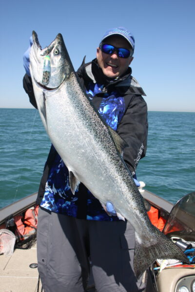 a man holding a big fish on lake ontratio