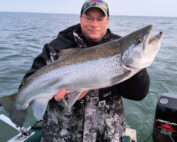 man holding a big fish on lake ontario