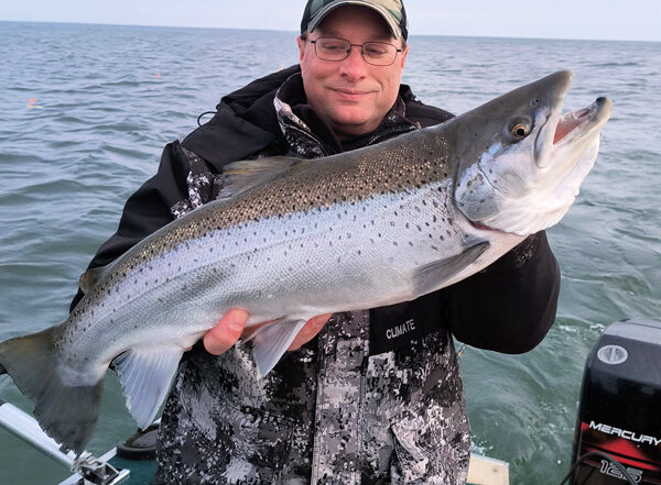 man holding a big fish on lake ontario
