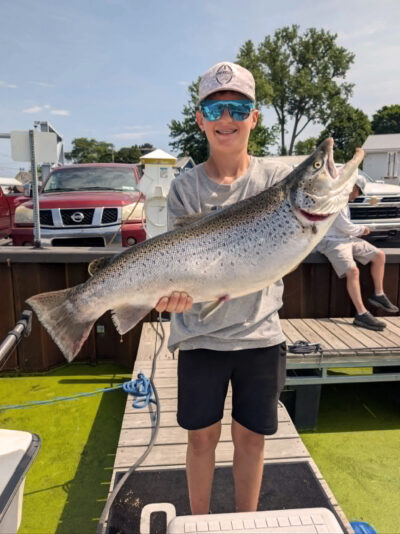 a young boy holds a big fish