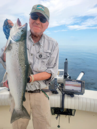 a man with sunglasses holds a big fish