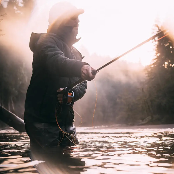 a man holding a fishing rod in a river